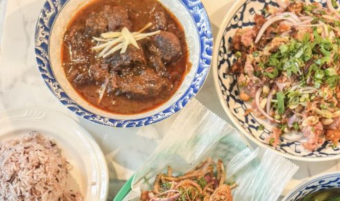 A table of Thai dishes with curry, larb and rice